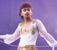 Greta Van Fleet's Josh Kiszka performs on stage, holding a microphone.