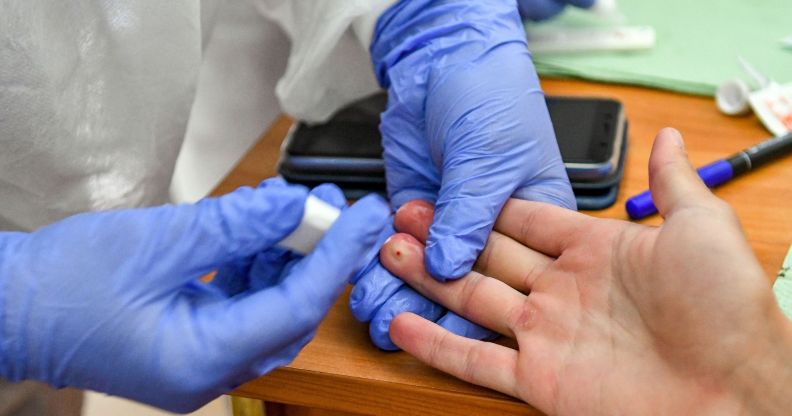 A person gets a finger prick test, often used to identify HIV.