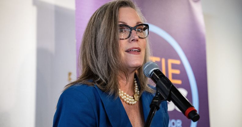 Arizona governor Katie Hobbs, in a blue suit, speaks into a microphone.