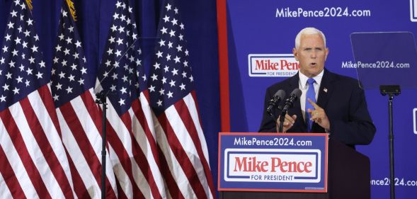 Former vice president Mike Pence stands at a podium reading "Mike Pence 2024" as he launches his presidential bid