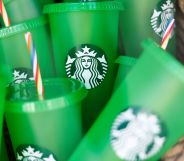 A set of green Starbucks brand cups with red, white, and blue straws in a pile together.