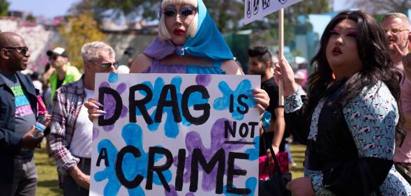 A person holds up a sign reading 'drag is not a crime' amid a protest against surging anti-LGBTQ+ bills in the US like Tennessee's drag ban