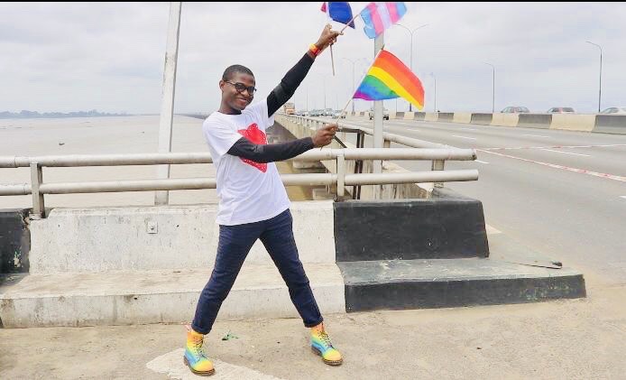 Joel pictured holding trans and a Pride flag. 