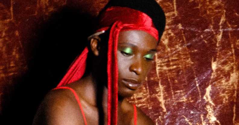 A character from Soft Bwoi - a Black man wearing a red durag and green eye shadow
