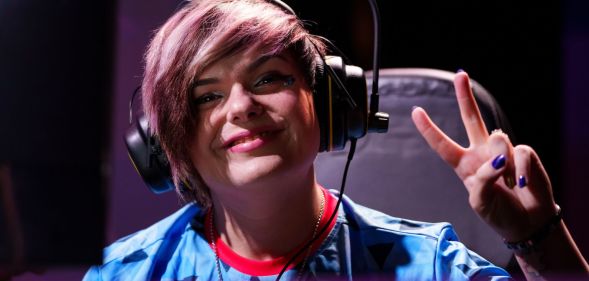 Emma 'Emzii' Rose sat in a gaming chair, making a peace simple during an esports event.