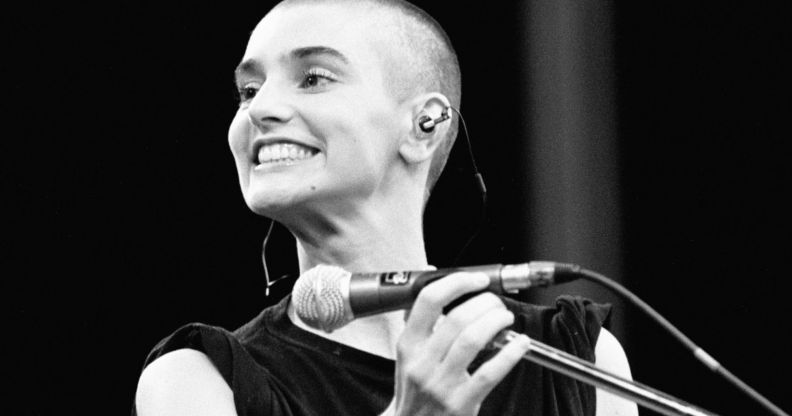 Sinéad O’Connor smiling on stage.