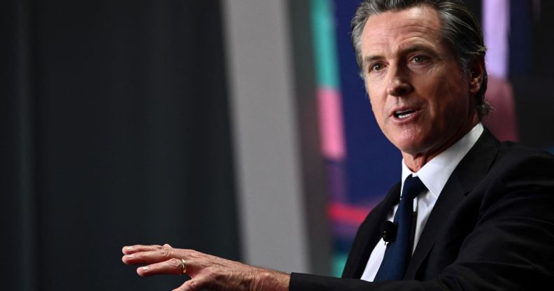 California governor Gavin Newsom wears a suit and tie as he gestures off screen.