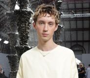 Troye Sivan in a white jumper dress at Paris Fashion Week.