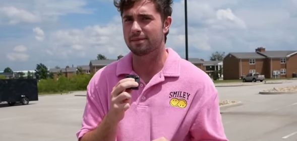 A picture of Bo Alford in a car park, wearing a pink shirt.