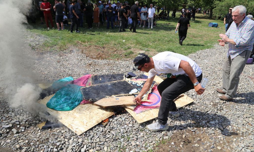 A right-wing, anti-LGBTQ+ crowd with Georgian flags damaged the decorations prepared for Tbilisi Pride and set fire to some placards and flags