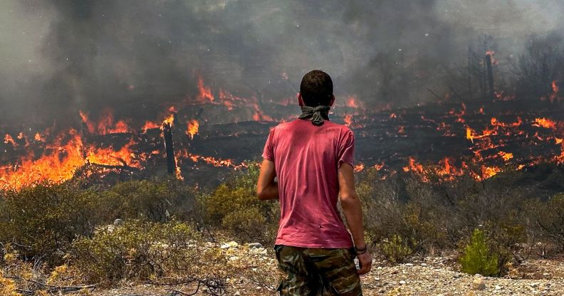 A person stares at the wildfires across Greece.