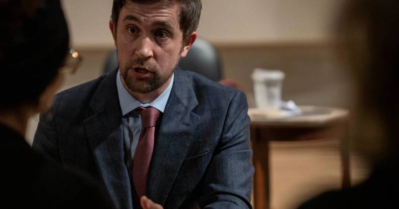 New College of Florida trustee Christopher Rufo speaks to two people during a meeting.