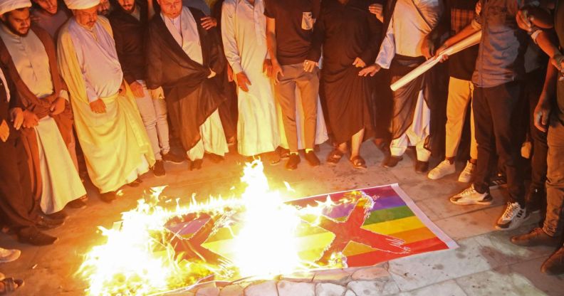 Homophobic protestors in Iraq burn two Pride flags with X's drawn on them