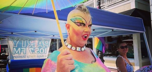 Florida drag queen Michael "Erika Rose" Travis holds up a rainbow umbrella and wears rainbow coloured clothing as she attends an LGBTQ+ event