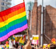 A person holds up a Pride flag during a protest.