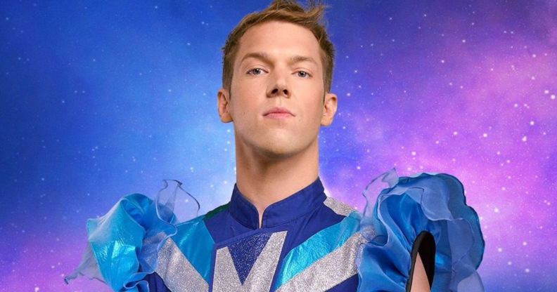 Drag Race Belgique judge Mustii in his promotional photo, wearing a blue and silver top with puffy blue sleeves.