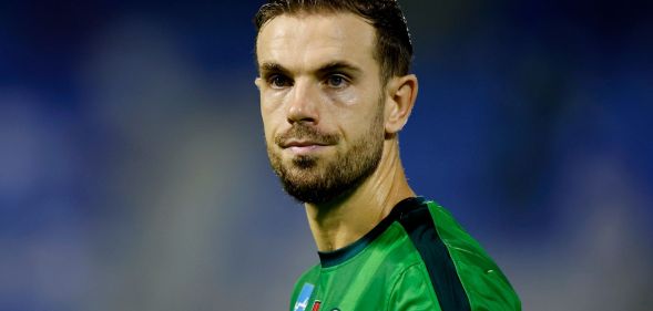 Jordan Henderson during a football match, wearing a green football shirt.