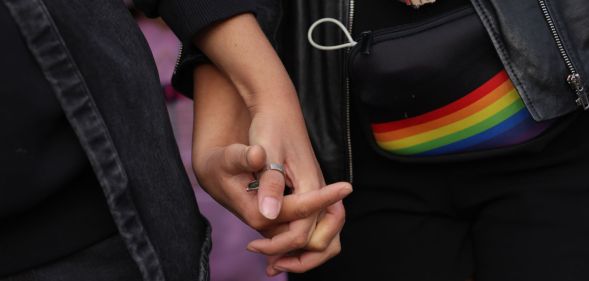 An unnamed same-sex couple holding hands.