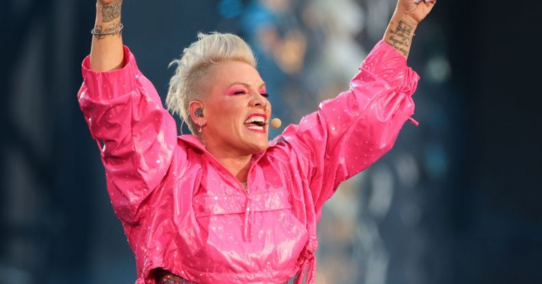 Pink, arms raised, sings into an ear-piece microphone.