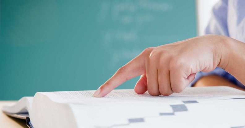 Person looking up words in a dictionary.