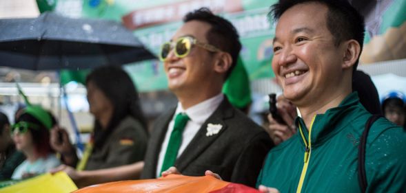 Two LGBTQ+ activists hold up a rainbow Pride flag during a protest in Hong Kong on queer rights, including recognition of same-sex partnerships and marriage equality