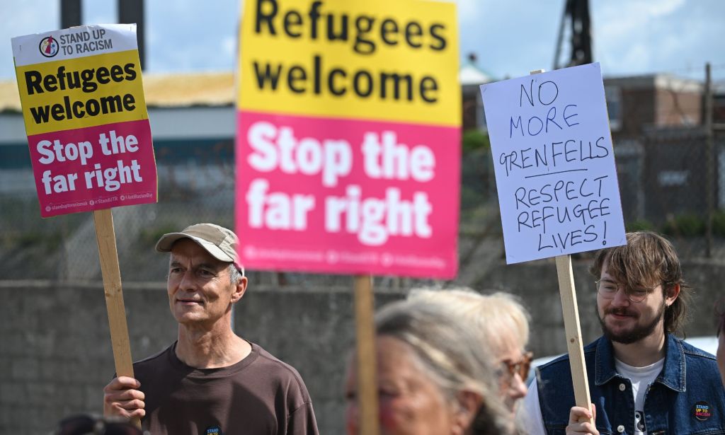 A person holds up a sign reading 'Refugees welcome stop the far right' as a barge is set to house asylum seekers, including LGBTQ+ people, who came to the UK through what the government deems 'illegal' means