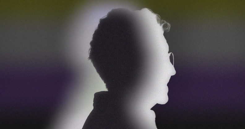 The image shows a silhouette of a person standing in side-profile against the non-binary flag colours.