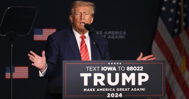 Donald Trump stands behind a podium reading "Trump"