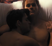 Jonathan Bailey (left) and Matt Bomer (right) lie in bed together in the trailer for Fellow Travelers