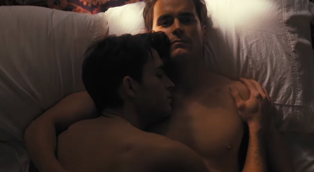 Jonathan Bailey (left) and Matt Bomer (right) lie in bed together in the trailer for Fellow Travelers