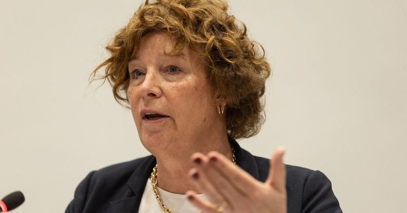 Petra De Sutter speaking into a pedestal microphone whilst gesturing with her hand.