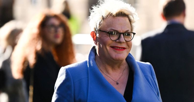 Comedian Suzy Eddie Izzard wearing a blue coat and red lipstick