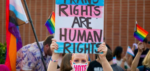 Protester holds up sign reading "trans rights are human rights"