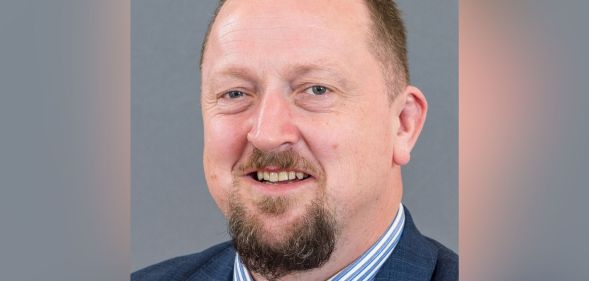 A picture of DUP councillor Colin Kennedy wearing a white and blue striped shirt, blue suit jacket and tie