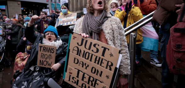 Protestors hold up signs reading 'trans rights now' and 'just another day on TERF island' as they slam the UK government for attacking the trans community as well as historically not tackling anti-LGBTQ+ hate crimes