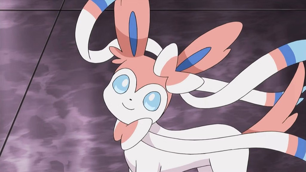 Image shows Pokemon called Sylveon, with blue and pink and white colourings: its overall appearance is similar to a fox.
