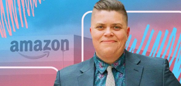 This is a picture of a trans man. He is wearing a bluish grey suit. In the background there is a logo of Amazon with a creative overlay using the colours of the trans flag, pink, white and blue