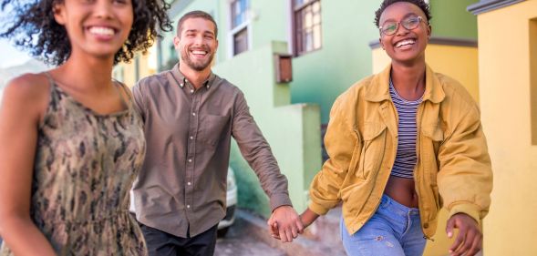 Three people walking down the street to symbolise a polyamorous relationship