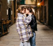 Stock image of two women kisses on an alley street