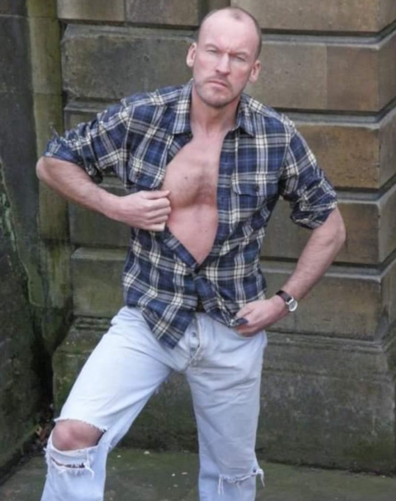 Paul Stag pictured holding his shirt open outdoors.