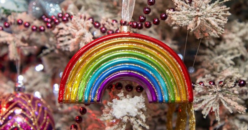 A Christmas ornament in the Shape of a rainbow on a festive Christmas tree