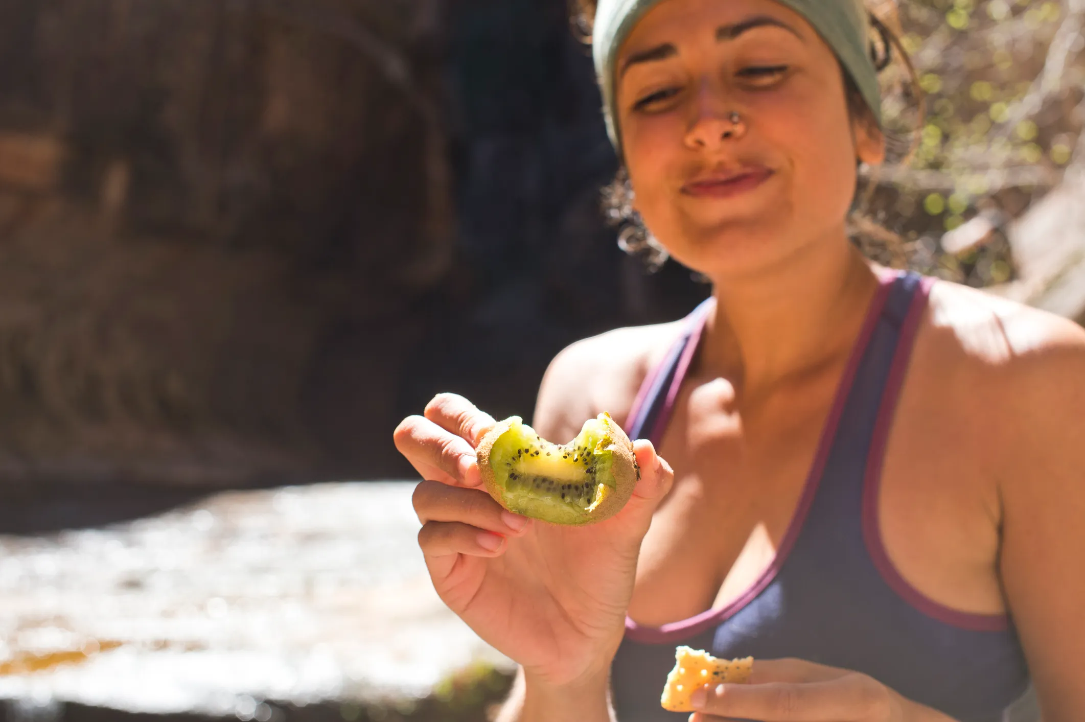 Person eating a kiwi fruit