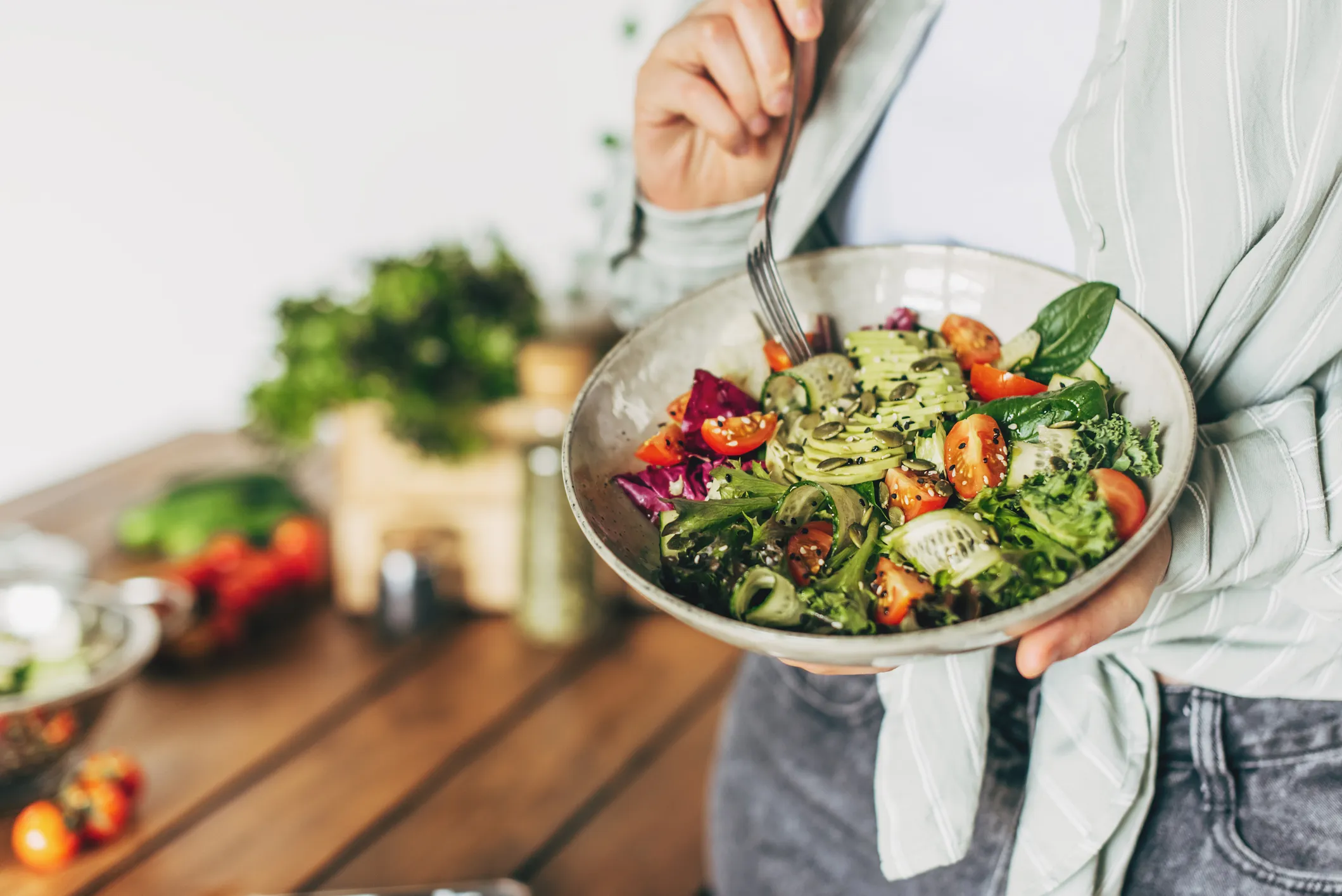 Person holding a bowl of salad